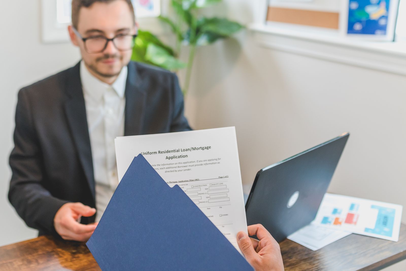 Mortgage paperwork being reviewed at a table before a lender switch.